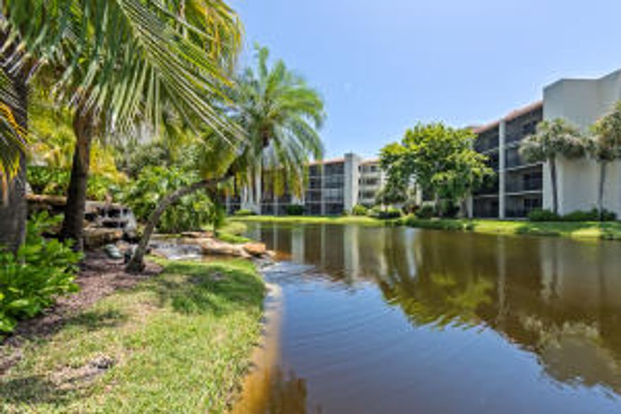 This beautifully renovated condo residence is just steps to the beach and pool.  The open floor plan has breathtaking views of the lake, waterfall and pool from almost every room. The large foyer that leads into the tiled living room has an extra storage closet. Large sliding glass doors  open to the covered, screened patio that overlooks  water. The renovated kitchen has wooden cabinetry,  granite counter tops with an under mount sink, full tile backsplash, recessed lighting a full compliment of appliances, and pantry. The Dining room and living room have tile on the diagonal, decorative ceiling lighting,  a dry bar with granite counters and wood cabinetry. The large master bedroom also has a spectacular view and has an attached updated master bath with a walk in closet. The guest bedroom is also spacious and the guest bath is renovated with granite and wood.  Amenities include clubhouse facilities, pool, and tennis courts. Perfect for vacation rentals-30 day minimum.