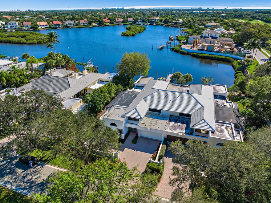 Courtyard Home with wide water views.  The home has been renovated in every way.  NEW... kitchen, baths, roof, floors, retiled and surfaced pool. and most systems.  Light and bright home that opens up to the pool and patio area with new summer kitchen and bar,