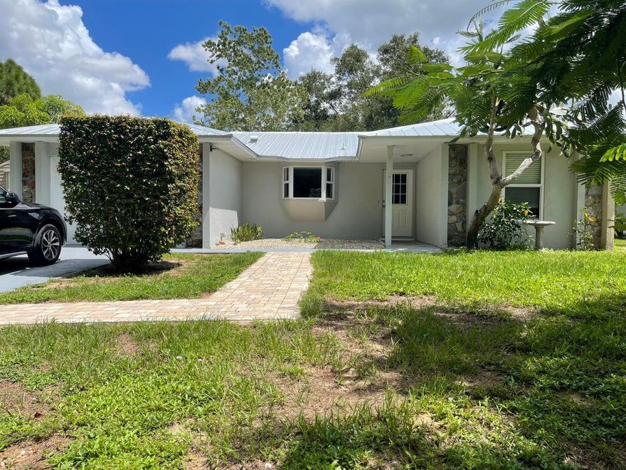 Welcome to your new home located in the community of Vero Lake Estates! Concrete block structure on .25 acres with a NEW metal roof installed 2022, NEW hurricane impact windows installed 2023. Home features 3 bedrooms, 2 bathrooms, garage. Master bathroom remodeled fall 2024. This home has amazing features including a spacious and bright kitchen with breakfast bar and a large picture window, built in bookcase, NEW brick walkway, the list goes on. The owners have taken much pride in updating the home including a NEW water softener in 2023, NEW Goulds water pump installed Jan 2025, and landscape additions for privacy.