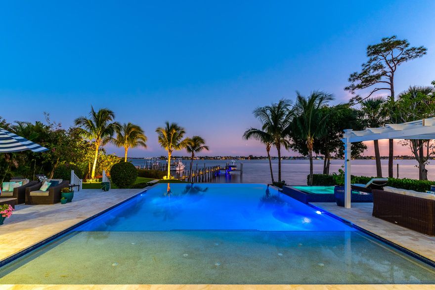 Welcome to this stunning waterfront estate featuring 6 bedrooms, 2 offices,  4.5 bathrooms, 4 car garage and in law suite. Situated on almost an acre, you have a private gated entrance for added security, professional landscaping, standing seam metal roof, impact windows and covered balcony. Step inside through the gorgeous double door front entry and find luxurious engineered hardwood floors, freshly painted interior, new Venato marble stone fireplace surrounded with Carrera mantel and Superior Vent free linear gas fireplace in great room, sliding doors that open completely and overlook the river.  Beautiful gourmet kitchen with quartz countertops, soft close cabinetry, gas stove with range hood, wine cooler and large island.