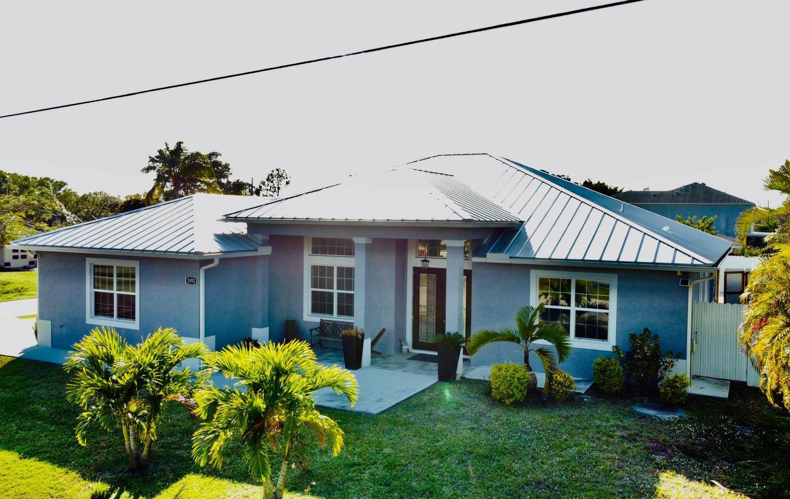 WELCOME !!!!!! to 2092, SW Airoso Blvd. Immaculate CBS home, No HOA. 4 BED + DEN, 3 BATH. with 2 - car garage, ready for immediate move in. The home offering ideal privacy on a Fully Fenced, Corner Lot. NEW METAL ROOF, IMPACT WINDOWS, and SPRINKLER System. Open split floor plan with 12' Ceilings, PORCELAIN TILE flooring Throughout, OVERSIZED QUARTZ COUNTER TOPS and Stainless Steel Appliances. A cozy Fireplace charmer in the living space. Spacious Patio with PAVERS, Porch, and Gutters. Close to Shopping Center, Restaurant and Beaches and more.