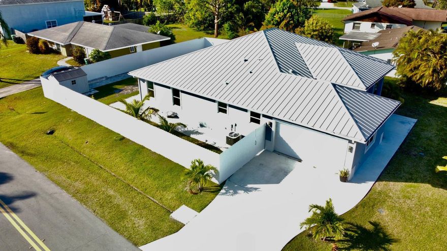 Stunning 2023 Custom -Build  Home - Corner in Port Saint Lucie.Welcome to 2092 SW Airoso Blvd, a beautifully designed custom home, this move in ready residence offers 4 Spacious Bedrooms a dedicated Office /Studio and 3 Full Bathrooms,12ft in main living areas. Metal Roof, Impact Resistant Windows.The open concept living area is adorned with  Large Porcelain title flooring. 2 Car Garage, Sprinkler system..Chef-style Kitchen featuring Massive Center Island. A cozy fireplace. Patio with Pavers and Gutters.. Located just minutes from shopping center, schools, parks,  and Beach.Schedule your private tour today-