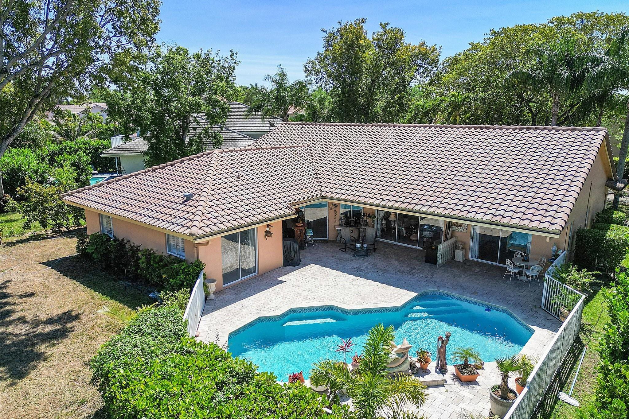 Your Dream Home Awaits! Located in the prestigious, guard-gated Hidden Hammock Estates, this stunning 4-bed, 2-bath, 2-car garage home offers a spacious split-bedroom floor plan with soaring vaulted ceilings, abundant natural light, and serene pool & canal views from every room. The kitchen boasts stainless steel appliances, kitchen island (counter recently tiled-onyx), and an open-concept layout. The private primary suite features dual walk-in closets, sliding doors to patio/pool. Primary bath offers whirlpool tub and separate shower. Step outside to a covered lanai, waterfall pool, lush fruit trees (avocado & mini banana), and tranquil water views. Recent upgrades include newer water heater, electrical panel, A/C (2021), and pool resurfaced and retiled (2021). Call for a private tour!