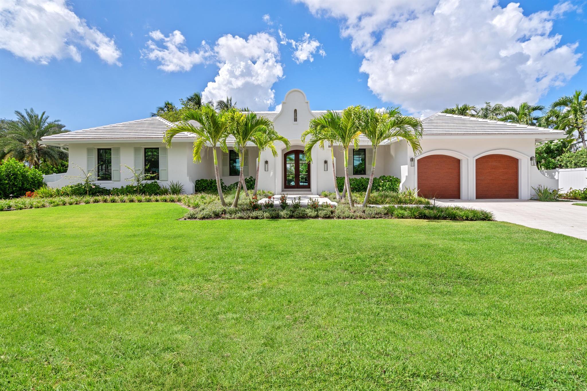 On a prime corner lot in Delray Beach's coveted Lake Ida enclave, this chic 2025-built contemporary residence offers an open floorplan great room, topped by a beamed vaulted ceiling, accessing the pool loggia and summer kitchen; four bedrooms with the primary bedroom opening to a private covered patio, a pocket office; and a cook-island kitchen with two-tone cabinetry, quartz counters and Thermador appliances
