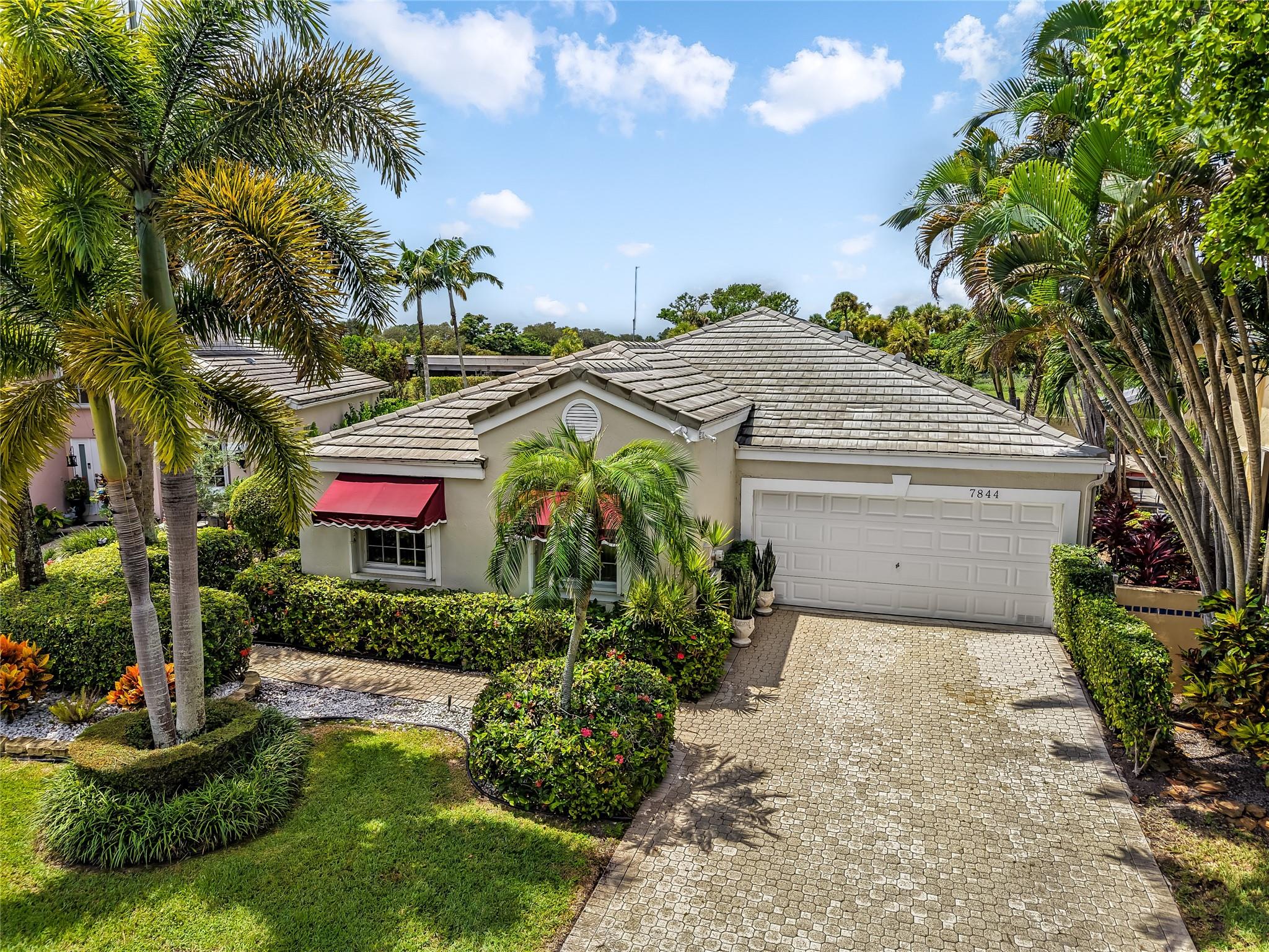 Welcome to prestigious Boca Point Community! This meticulous and well maintained 3 bed and 2 bath home includes, updated kitchen cabinets, granite countertops, new stove and microwave installed 2025, wood and tiled flooring, volume ceilings, custom mirrors, full house Generac Generator installed in 2023, pool pump installed in 2022, new garage door motor 2021, complete shutters 2019, A/C 2018, oversized patio includes Luminet shades for privacy. Well maintained pool and lush landscaping with Tiki Hut for outdoor enjoyment. Boca Point offers optional country club membership. This home is located in top rated school zone, and minutes from world class dining and shopping!