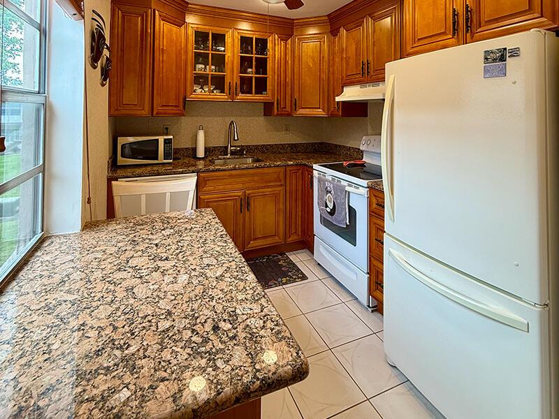 This fully furnished, turnkey 2-bedroom, 2-bath 55+ condo in Kings Point, Delray Beach, is ideal for a seasonal escape. The home features a spacious, sunlit living area and an updated kitchen with elegant cabinetry and countertops. Both bathrooms are tastefully tiled, with the primary bath offering a walk-in shower. The primary suite includes a walk-in closet for added convenience.Relax on the enclosed, tiled patio that offers tranquil garden views. Additional features include an in-unit washer and dryer. Kings Point has resort-style amenities, including golf courses, multiple clubhouses, swimming pools, fitness centers, a complimentary community bus, and much more! With all furnishings, kitchenware, and linens included, this condo is move-in ready.