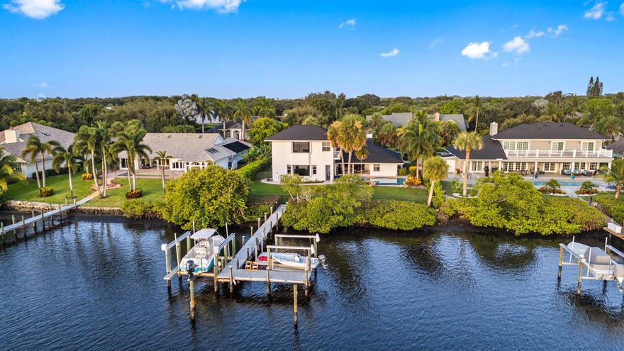 This coastal styled home is loaded with natural light and enjoys serene Loxahatchee River views with picturesque sunsets and beautiful reflections on the river at first light!The 16,000lb & 7000lb lifts will hold your boat or jet skis and are a scenic 15 minute ride to the Jupiter Inlet, a natural sandbar or a dozen quality restaurants.  The spacious interior is highlighted by ground floor and upper level master suites.  The well maintained home includes these recent updates: new stone coated metal roof('23), all 3 ac units and upper level water heater ('22) , washer, dryer and pool pump ('21), tankless water heater, pool heater and all kitchen appliances ('16&'17). Porcelain tile throughout main floor, cozy semi private bar room with wet bar, wine cooler and kegerator.