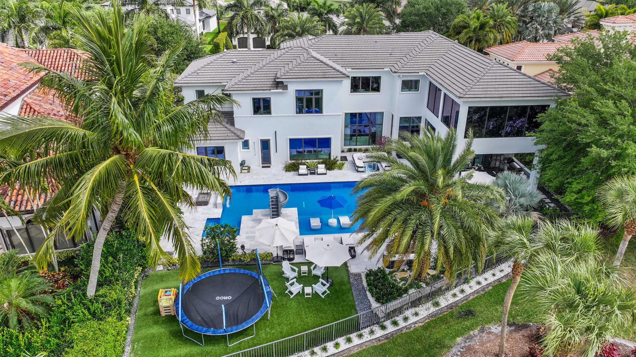 Rare opportunity to own a luxury custom estate with full golf equity membership available in prestigious Mizner Country Club. This exceptional property offers 6 bedrooms, plus two offices/club rooms and home theatre. Marble floors, soaring ceilings, a chef's kitchen, elevator, and Lutron & Savant smart home systems. Enjoy a completely rebuilt custom theatre whole-house HEPA air filtration, and a 2nd floor gym overlooking the golf course from the primary suite for breathtaking views while you exercise.Designed for both relaxation and recreation, the estate features two elegant club rooms--one on each level--ideal for entertaining, lounging, or creating additional versatile living spaces.Outdoors, indulge in a resort-style backyard featuring a covered lanai with outdoor kitchen, lush