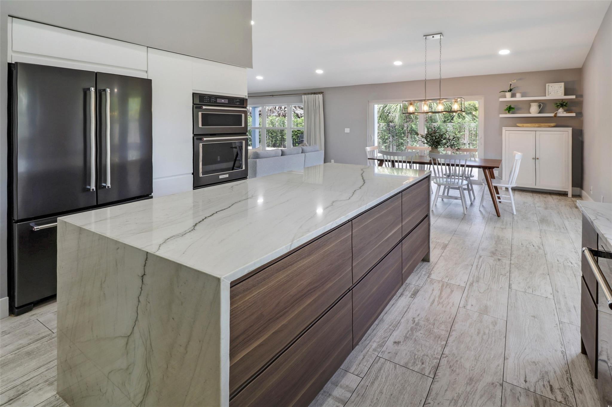 Meticulously renovated home, just appraised! Looks and feels like new construction with a level of sophistication and quality rarely seen at this price point. Including BRAND NEW IMPACT WINDOWS, METAL ROOF and spray foam insulation(2025). A bright and airy ambiance is created by the tall ceilings and spacious layout. A modern kitchen with high-end KitchenAid appliances, waterfall quartz island, and soft-close cabinetry w/integrated lighting. Lutron Caseta smart switches and screwless plates control LED lighting throughout the home. The Primary bedroom with 5 piece bath is on the first floor along with the laundry room, half bath and a bonus room (den/playroom/office). Outside, you have a huge backyard on an oversized lot with a sparkling pool and water feature, perfect for entertaining.