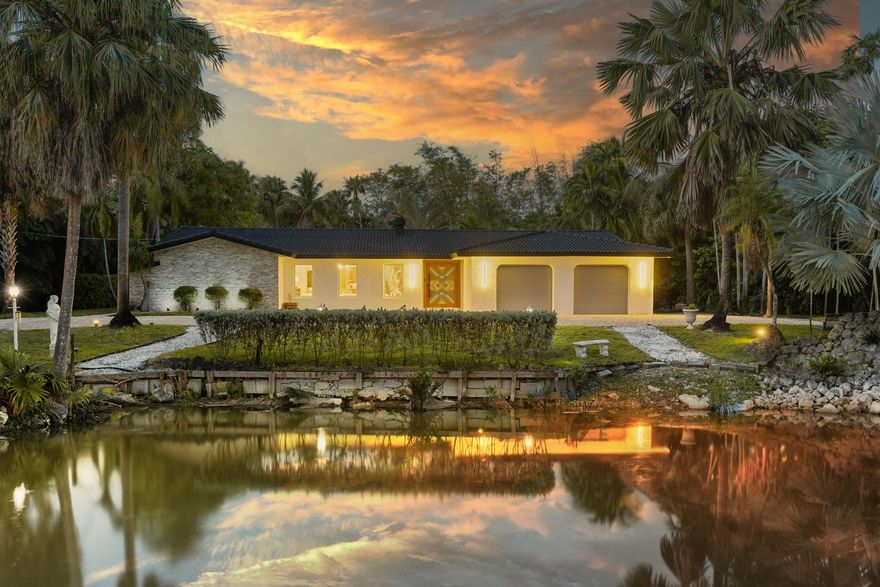 Remodeled tropical oasis in the heart of it all! This one-of-a-kind 4-bedroom, 4.5-bath estate sits on an incredible 1.4-acre lot in prestigious Plantation Acres. A true private paradise, the grounds feature lush, resort-style landscaping with botanical gardens, and a fire pit retreat. A beautiful oversized pond with waterfall and fountain is surrounded by expansive decking, creating a serene setting. Custom Electronic gates open to a massive driveway, with ample space for RV and boat parking. Enjoy a spectacular and expansive pool and patio area designed for ultimate outdoor living and entertaining. Inside, the home showcases rich hardwood flooring, a stunning kitchen, and quality upgrades throughout. Impact windows too! Don't miss this opportunity for this Grand Estate!