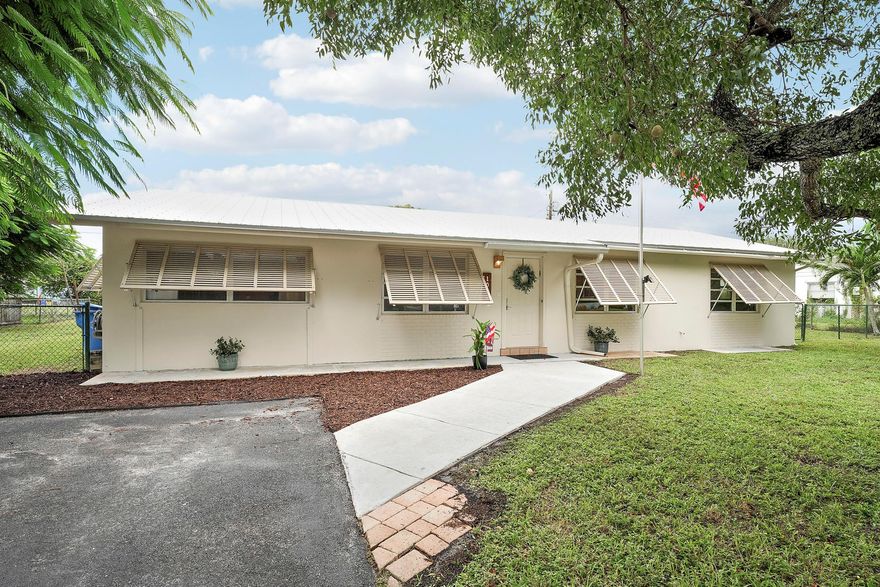 Located in the sweet little town of Haverhill, Florida; this charming home offers a spacious layout and endless potential. Three bedrooms, two bathrooms, plus a sprawling bonus room and cozy den. The large kitchen features abundant cabinetry, providing plenty of room for storing all of your cooking essentials. The property sits on a beautiful, expansive lot shaded by mature trees, creating a serene outdoor retreat ideal for relaxing or entertaining. A newer metal roof and fully fenced back yard adds peace of mind and includes a generous storage shed- perfect for a workshop or storing outdoor equipment. Pineway Drive is located just minutes from I-95 and Florida's turnpike, offering easy access to the rest of South Florida. You'll love being near Haverhill Park with its playground, sports