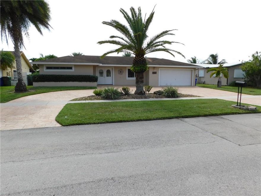 Outstanding Pembroke Lakes Home with Huge Stamped Concrete Open Patio Overlooking the Lake Plus Roofed Area For Cooking and  Tiki Hut. Spacious Stamped Concrete Circle Driveway, Parking for Eight Vehicles. Beautiful Custom Kitchen With Wood Cabinets, Granite Counter Tops and Stainless Steel Appliances, (Gas Stove), Built in Wall Unit In Living Room with 3 TV'S that Stay, Entertainment Area with Custom Bar and Cabinets With Granite Counter Tops Plus TV With  Double French Doors Leading to Patio Area.  Great House for Entertaining and Enjoying Life.