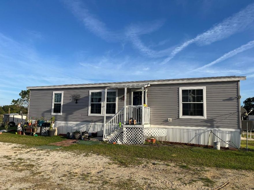 Don't miss the opportunity to own 5 acres featuring a 2020 double-wide mobile home with 3 bedrooms, 2 bathrooms, and 1,303 square feet of living space. The property includes three separate entrances and currently carries an agricultural exemption, keeping taxes low. It also holds a licensed farm designation, allowing for pole barns, animal structures, RV or container storage, and more. Consisting of four 1.25-acre lots—three on 310th Street and one on 308th—the third lot on 310th has its own entrance gate, culvert, and filled house pad ready for an additional home. A 48 x 60 barn with a 14-foot center height and 11-foot sides features aluminum trusses built to last a lifetime. The property is fully fenced and cross-fenced, with multiple sheds, storage buildings, a chicken coop, and mango and mandarin trees. Inside, the home offers a split floor plan with a spacious master suite, interior laundry room, and large eat-in kitchen. Secondary bedrooms are located on the opposite side of the home and share a full bathroom. This stunning property provides plenty of space for the whole family to enjoy, with room for animals, outdoor living, and future expansion.