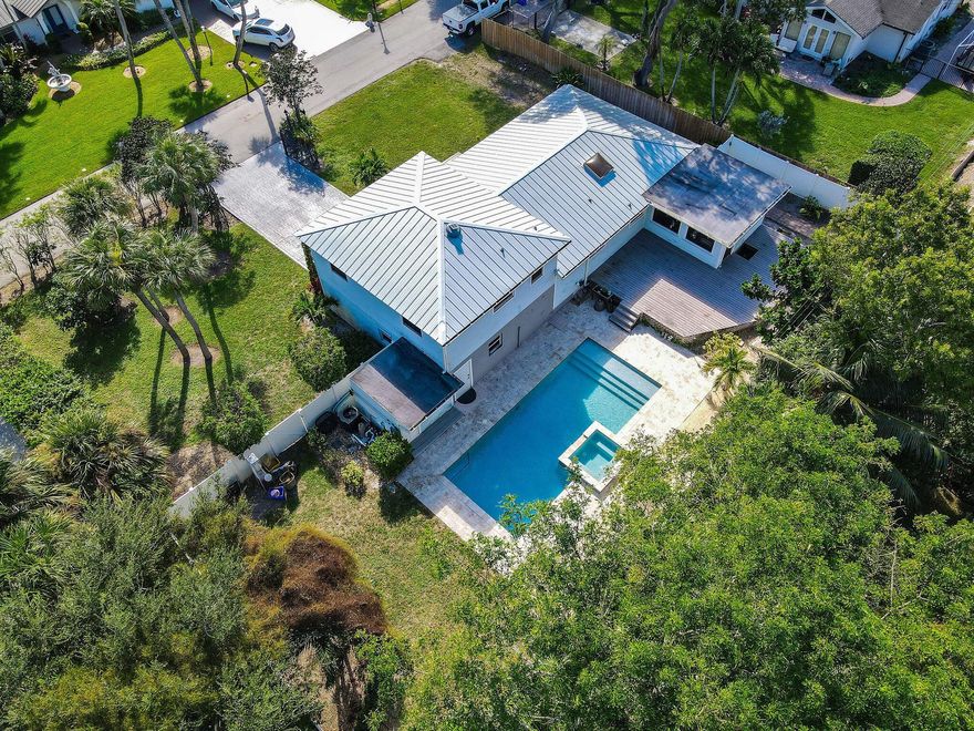 Breathtaking and spacious 1/3 acre homesite! Great opportunity to live on the 'Holiday Tree' Street! The beautiful tree-lined neighborhood of Snug Harbor Estates is one of Palm Beach Gardens most desired neighborhoods. Spectacular multi-level residence has 3 beds, 2 baths and 2 car garage! This home is inviting, cozy and updated. Warming vibes are given with dark laminate flooring, neutral interior walls with luxury baseboard. Large windows throughout bringing in plenty of natural lighting. Spacious kitchen equipped with stainless steel appliances, white cabinetry, stylish granite countertops and decorative backsplash, built-in wine cooler and pendant lighting over the eat-in kitchen countertop bar. From the kitchen, the open floor concept pairs a formal or casual dining area. A wonderful large homesite adorned by a beautiful tropical pool and patio. The oversized backyard gives you the opportunity to create the Florida paradise of your dreams! Snug Harbor Estates is a no HOA  Community. This oversized homesite has plenty of space to bring your boat and your RV! Perfectly situated - Close to shopping, restaurants, entertainment, I-95, Turnpike, Palm Beach State College, pristine beaches and so much more.