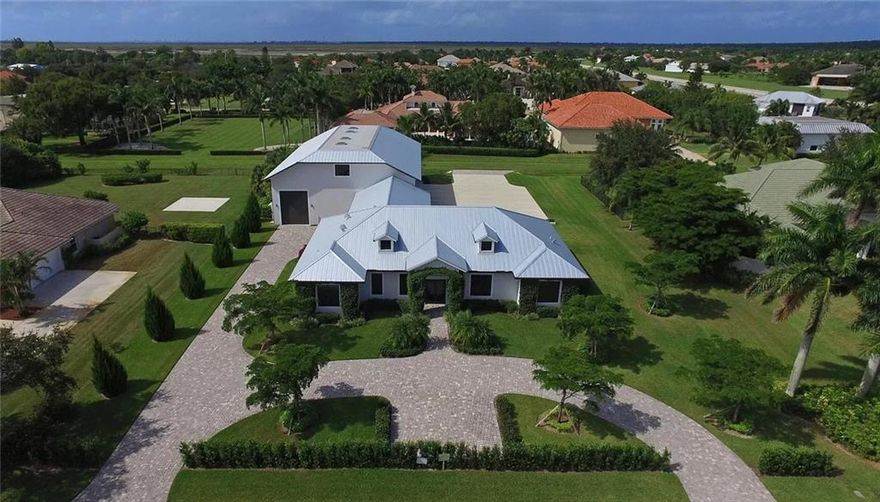 Just 3 lots in from a private runway, this property boasts a 4,920sqft hangar that can fit multiple aircraft, rv, boat, and/or horse trailer. The home is tastefully finished as a large open concept design with volume ceilings throughout. Marble countertops grace the kitchen counters and entertainer's island. Enjoy indoor/outdoor living in season as the large collapsing impact doors open to the covered patio and outdoor kitchen with hooded grill. Large electronic flex doors offer access from 3 sides to the hangar. Commercial sized ''Big Ass Fan'' provides airflow. Air-conditioned space above hangar ideal for pilot, housekeeper, or guests. Oversized 3-car garage offers full climate control with AC. All impact windows and doors. Located in the heart of Wellington's Equestian festivities.