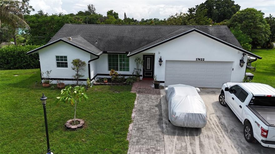 This stunning 1710 sq ft, 3-bedroom, 2-bathroom house in Loxahatchee is a must-see. It boasts a spacious, upgraded kitchen, renovated bathrooms, and a 2-car garage. The property features central air, stainless steel appliances, and a washer/dryer. Situated on a fenced-in 1+ acre yard with a powered gate opener and Ring doorbell at the main gate with multiple security cameras. You'll enjoy a large screened-in patio, Impact windows, sliding doors and an updated well water filtration system. Pet-friendly. It is conveniently located just one mile from schools, Publix, Winn-Dixie, Starbucks, and more. Renters are responsible for electrical and other utilities. Small pets are allowed. Available November 1st, 2024.