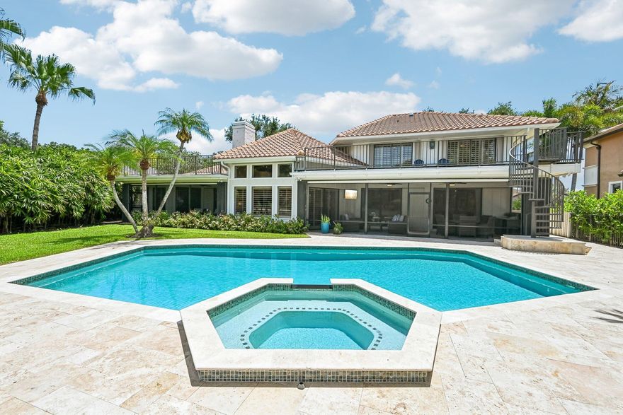 Welcome to an exceptional luxury residence in the prestigious PGA National community of Palm Beach Gardens—where timeless design meets modern refinement.  Set on a sprawling 1/3-acre homesite with sweeping views of the 15th hole on the renowned The Match Course, this custom-built estate offers 4 bedrooms + loft, 4.5 bathrooms, and a 3-car garage, delivering the ultimate in privacy, elegance, and resort-style living.  Step inside to a dramatic oversized living room featuring soaring 20-foot wood ceilings and a striking two-story travertine fireplace—an architectural centerpiece that defines the home's grandeur. The thoughtfully designed floor plan includes an additional family room just off the kitchen, perfect for both entertaining and everyday comfort.  Extensively remodeled from 2023-24 the interior showcases restored original travertine flooring in the formal living and dining areas, complemented by new hand-scraped hardwood floors throughout. Freshly painted walls, ceilings, trim, and plantation shutters, along with updated designer lighting and fixtures, create a cohesive, elevated aesthetic.  The custom chef's kitchen is a true showpiece, featuring premium KitchenAid appliances including a French door refrigerator, double oven/microwave, and built-in cooktop. Elegant Taj Mahal quartzite countertops, custom cabinetry with 42" uppers, a large farmhouse sink, and a spacious breakfast bar with seating for four are complemented by a butler's pantry with additional storage and display cabinetry—perfect for hosting.  The luxurious primary suite offers a private retreat with a sitting area, direct access to the screened porch, and dual walk-in closets. The spa-inspired bathroom features marble flooring, an oversized soaking tub, a glass-enclosed shower, and an extended dual vanity.  All 4.5 bathrooms have been completely renovated, including a convenient cabana bath with direct access to the outdoor living space.  Outdoor living is reimagined with a full pool and patio renovation completed in 2025, including a new travertine deck, updated pool tile, variable speed heater, and new screen enclosure. Enjoy a heated pool and spa surrounded by lush, mature landscaping, along with an upper Trex deck ideal for relaxing or entertaining.  Additional highlights include:  Tile roof (2020) 3-car garage with new impact doors Spacious laundry room with quartz counters, abundant cabinetry, and drop zone entry from garage  This one-of-a-kind property combines luxury finishes, thoughtful design, and an unbeatable golf course setting—offering a rare opportunity to own a fully renovated estate in one of Palm Beach Gardens' most sought-after communities.