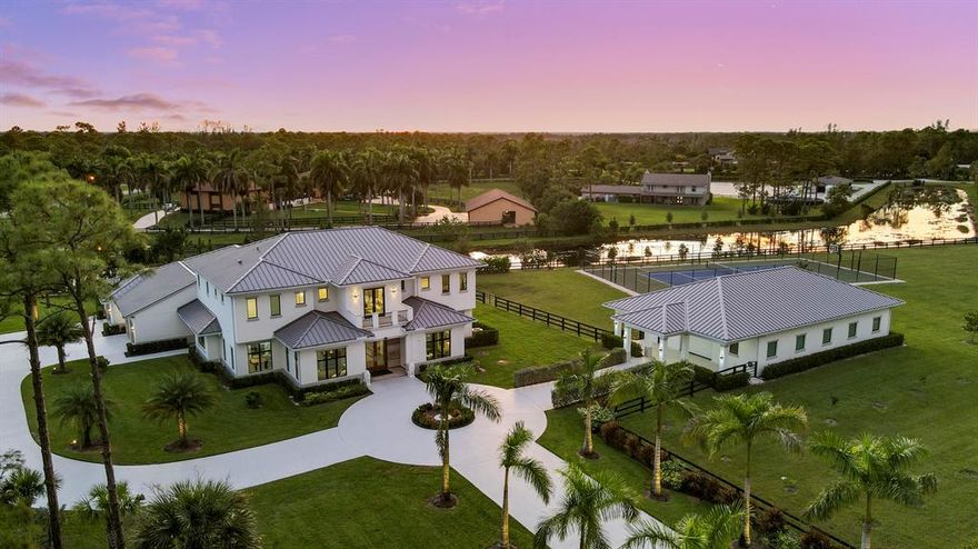 Gorgeous Custom Estate Home located on over 5 acres in the highly sought-after Equestrian Community of Homeland. This 5 Bed 6.5 Bath 2020 construction looks and feels brand new. The main home features 12' high ceilings, custom millwork, wood/tile floors, grand spiral staircase with elevator alternative. Enjoy two primary owner's suites, one on each level. Both suites include custom his/her closets/bathrooms, large window views, and breakfast bars. In addition, there is a 3000 Sq Ft climate-controlled garage/showroom/workshop for your prized collections (or can be easily converted back to 10 stall center isle stable). Peace of mind is guaranteed by full impact doors and windows, whole house generator (powered by 1000 gallon propane tank), and whole house RO water system.