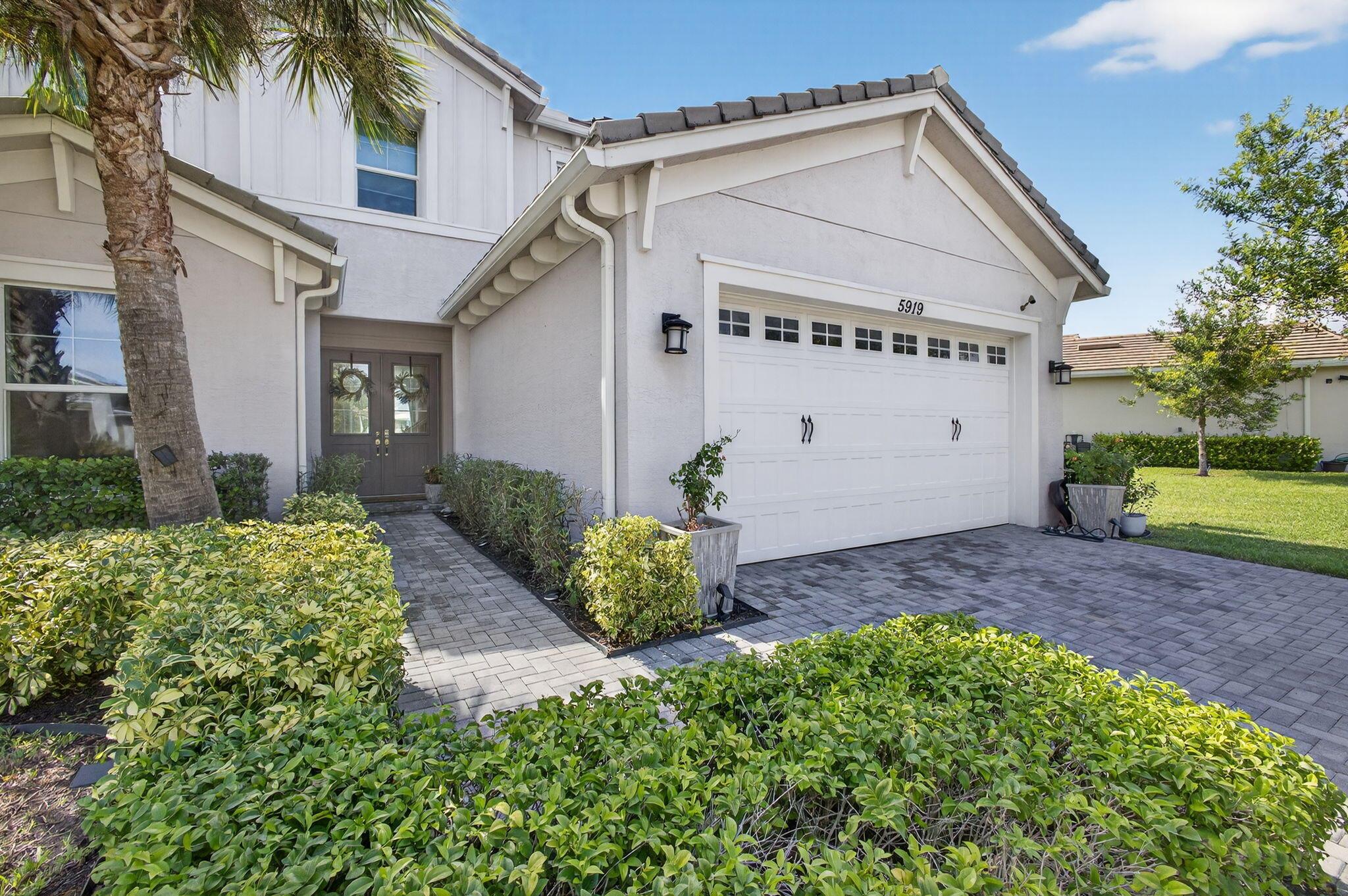 Stunning Lakefront Home with Private Pool in The Hammocks of Westlake! Welcome to this beautifully upgraded 4-bedroom, 3.5-bath, 2-story home perfectly situated on the lake in the highly sought-after community of Westlake. Featuring impact windows throughout, elegant French entry doors, and a pavered driveway, this home combines style, comfort, and peace of mind. Inside, enjoy beautiful lighting throughout, a formal dining area, living room, and family room, plus a large kitchen island with designer lighting above. The kitchen boasts stainless steel appliances and gorgeous gray cabinetry, flowing seamlessly into the spacious living areas with tile flooring throughout. Upstairs, you'll find the laundry room and a versatile loft that could easily be converted into a 5th bedroom.