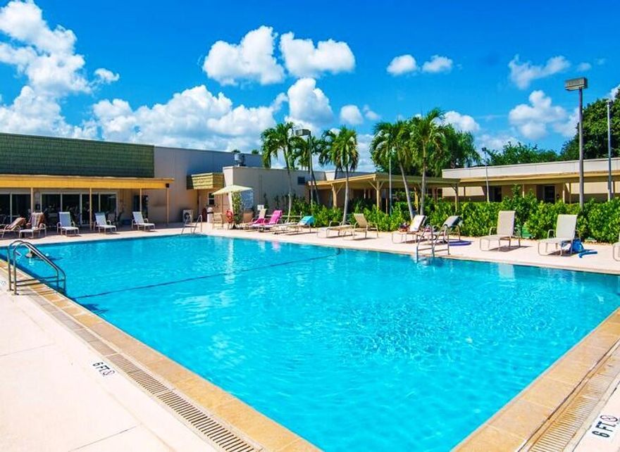 Furnished first-floor unit across from the clubhouse and pool. Updates include impact windows, slider, AC, flooring, appliances, under-cabinet lighting, tile backsplash, ceiling fan, and a tiled walk-in shower. Enjoy peaceful garden views in this active 55+ community offering golf, tennis, fitness, shuffleboard, billiards, cards, social activities, a heated infinity pool, hot tub, and more in beautiful Vista Gardens.