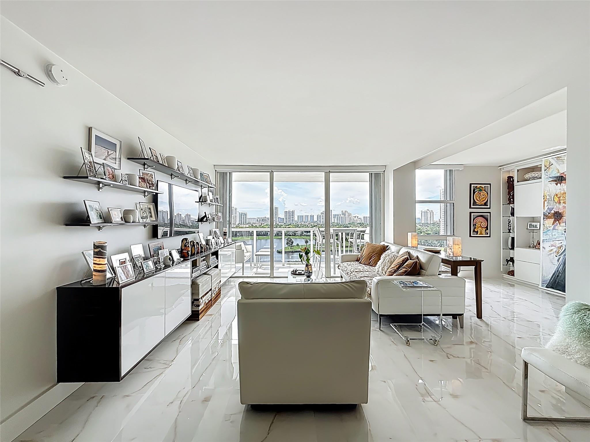 Architect’s residence with turnkey fully furnished option. 180-degree views of sunrises over the ocean, majestic sunsets, shimmering moonrises & serene lake reflections. Innovative living area seamlessly integrates the LR, DR & 2nd BR for open concept, but can be portioned into an office/bedroom w/ a panel pocket wall system. Artfully concealed Murphy bed creates a BR w/ closet & en-suite bathroom. Interior features: 3D accent walls, exquisite mother of pearl tile, custom kitchen, bar w/ built-in cabinets, entertainment center w/ floating shelves, motorized blackout shades, WIC, lots of storage, hurricane shutters & deeded parking (2nd available). Location is on the Soffer nature trail & Turnberry lakes…Walk to Aventura mall, restaurants, houses of worship, dog park, horse track
