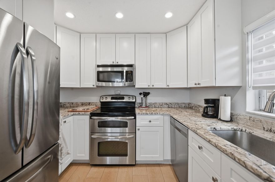 Stunning fully remodeled first floor 2/2 corner unit in the exclusive City of Atlantis! Step into a bright, modern space with gorgeous porcelain look tile floors, a beautifully updated kitchen, and completely renovated bathrooms. Your patio opens directly to the pool — it feels like having your own private oasis — all while enjoying peaceful golf course views from your living room. Nothing to do but move in and start living the resort lifestyle. No mandatory memberships, just pure comfort, convenience, and serenity inside this gated, beautifully maintained community.