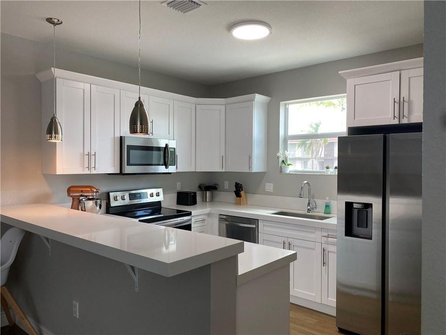 Looking for new construction in Broward County? This beautiful 3 bedroom, 2 bath home was built in 2020 and features hurricane impact windows and doors, volume ceilings, wood-look tile floors, a gorgeous kitchen, walk-in laundry room, tankless water heater and energy efficient A/C.  Enjoy the shopping and restaurants along Hollywood Blvd and ArtsPark at Young Circle all within walking distance!  **The home shares an adjoining concrete wall with the next door neighbor (duplex style), but has its own private and fully fenced backyard as well as a separated driveway and front door.