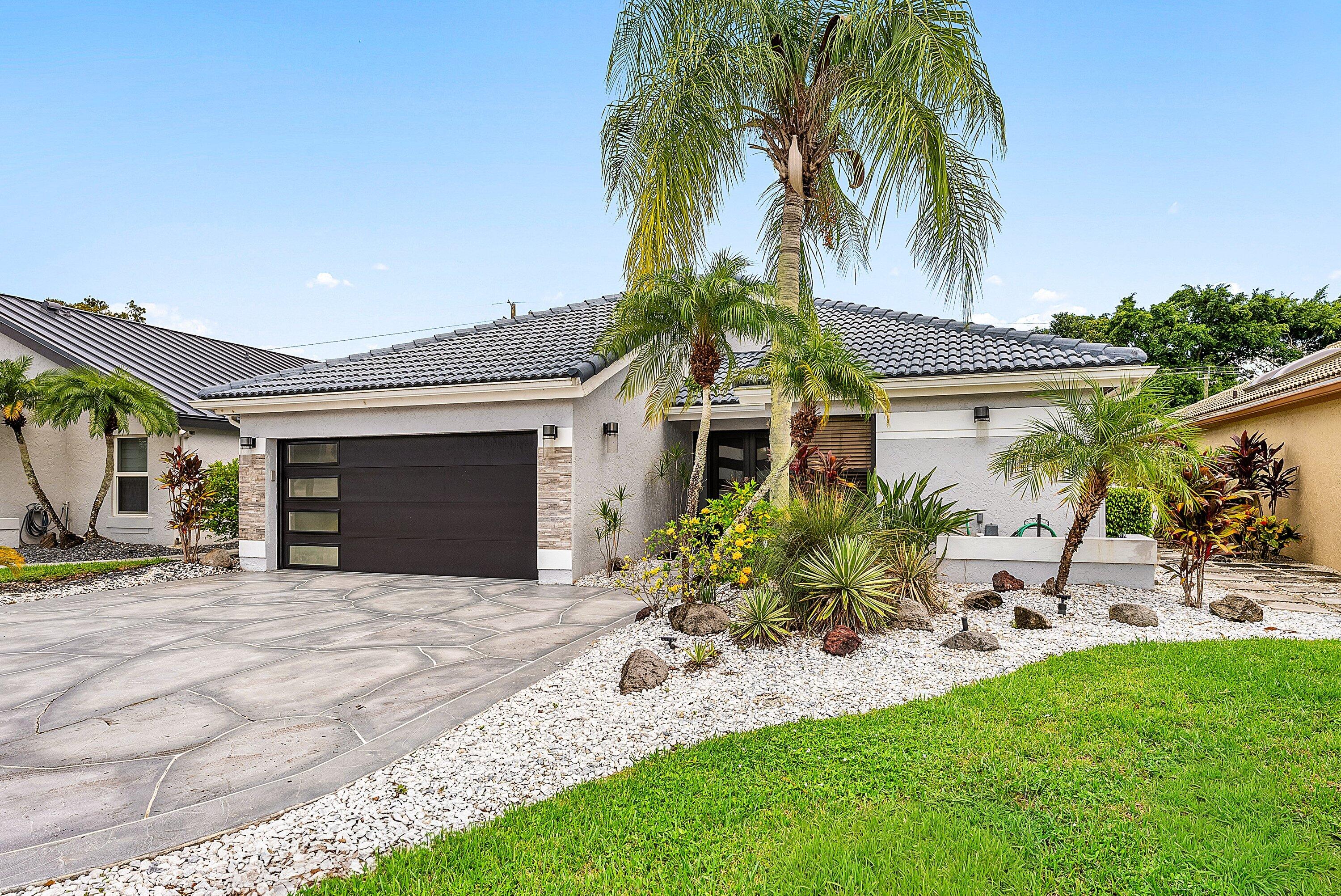 Nestled on a quiet cul-de-sac street in the prestigious Boca Woods Country Club, home features new cabinetry, quartz countertops, subway tile backsplash, premium appliances including Bosch, Verona induction cooktop/range & an expanded pantry. The 3rd bedroom/office was expanded into the former atrium, adding a large impact skylight & extra closet. Recent 2025 updates: new flooring, completed master closet & additional recessed lighting. Exterior upgrades include yard lighting, Clusia trees for privacy, a stained side deck, and a new garage door opener. Boca Woods Country Club offers resort style amenities, including 2 championship golf courses, Har Tru tennis courts, pickleball, state of the art fitness center, spa, game room, fully renovated clubhouse, fine dining and much more.