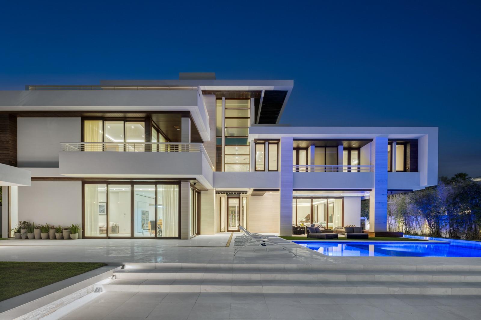 Welcome to 10 Pelican Drive—a super-custom tri-level organic modern estate blending clean lines with natural materials. 9300+sf Total Area built in 2014 with a major exterior renovation completed in 2024. 110ft of ocean-access dockage on a 130' deep lot. An orchid-lined courtyard with ipe yoga deck opens to interiors of polished limestone, ipe hardwood finished in a Brazilian baked varnish, and stone walls bathed in light. Sapele mahogany framed impact glass reveals an 80-ft heated lap pool and sun shelf. Exterior pergola for outdoor dining and BBQ, with an opportunity to design your own summer kitchen. A Miele-appointed gourmet kitchen with gas stove, generator, elevator, and third-floor entertainment level with panoramic Intracoastal and skyline views complete this rare offering.