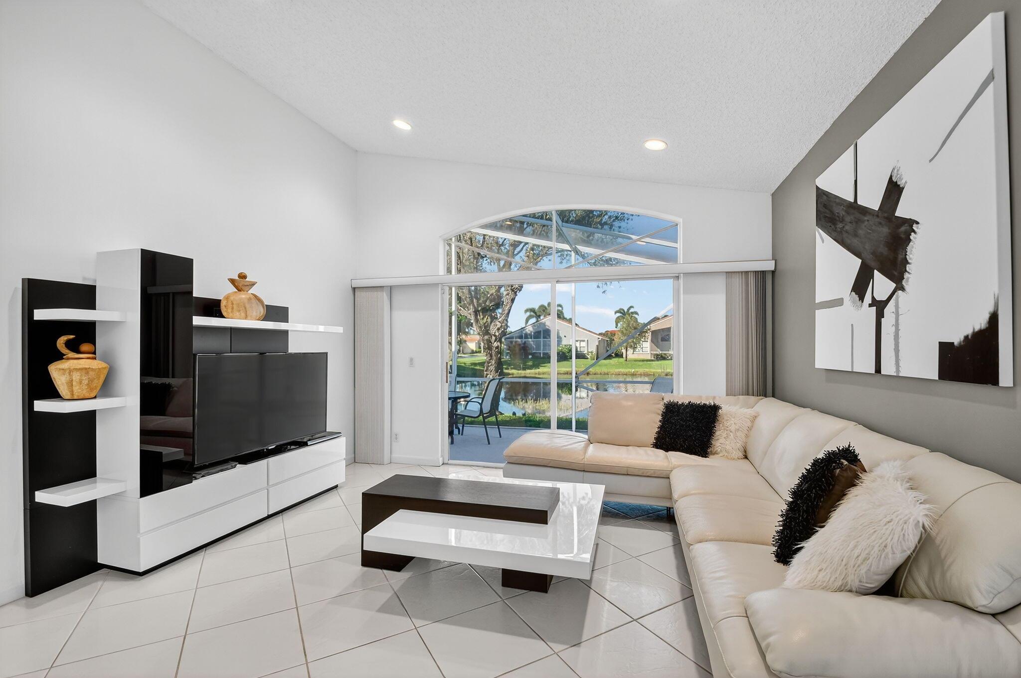 Step into a life of true peace in this beautifully maintained 3-bedroom, 2-bathroom home, The third bedroom has been professionally converted to a spacious den, perfect for an office, library, or media room. Imagine starting your day on the screened patio, sipping coffee as you overlook the sparkling lake and fountain. Perfectly situated on a very quiet, no-through-traffic street, you get the best of both worlds: genuine tranquility and unparalleled convenience, as this home is perfectly positioned within easy walking distance to the pool, clubhouse, and the heart of it all.The freshly manicured exterior immediately invites you in, and once inside, high ceilings and expansive windows flood the space with natural light, creating an open and uplifting atmosphere where tile flooring