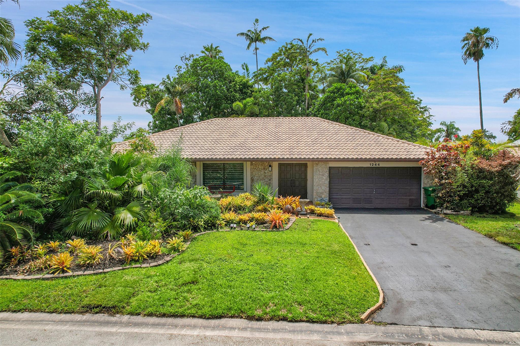 This spacious 4-bedroom, 2.5-bath home features an open, airy layout with abundant natural light thanks to desirable east-west exposure. The formal living & dining areas boast soaring vaulted ceilings, while the large open kitchen seamlessly connects to a breakfast nook & inviting family room. The split-bedroom floor plan ensures privacy, with the expansive primary suite offering his-and-her closets and a en-suite bathroom with a walk-in shower. Step outside to an oversized screened-in pool perfect for relaxing or entertaining year-round. Highlights include a New A/C (2025), full accordion hurricane shutters, 2-car garage. Situated within a protected —Certified Natural Habitat & Lake, this well-maintained home provides peace, privacy, and exceptional value in a truly serene setting.