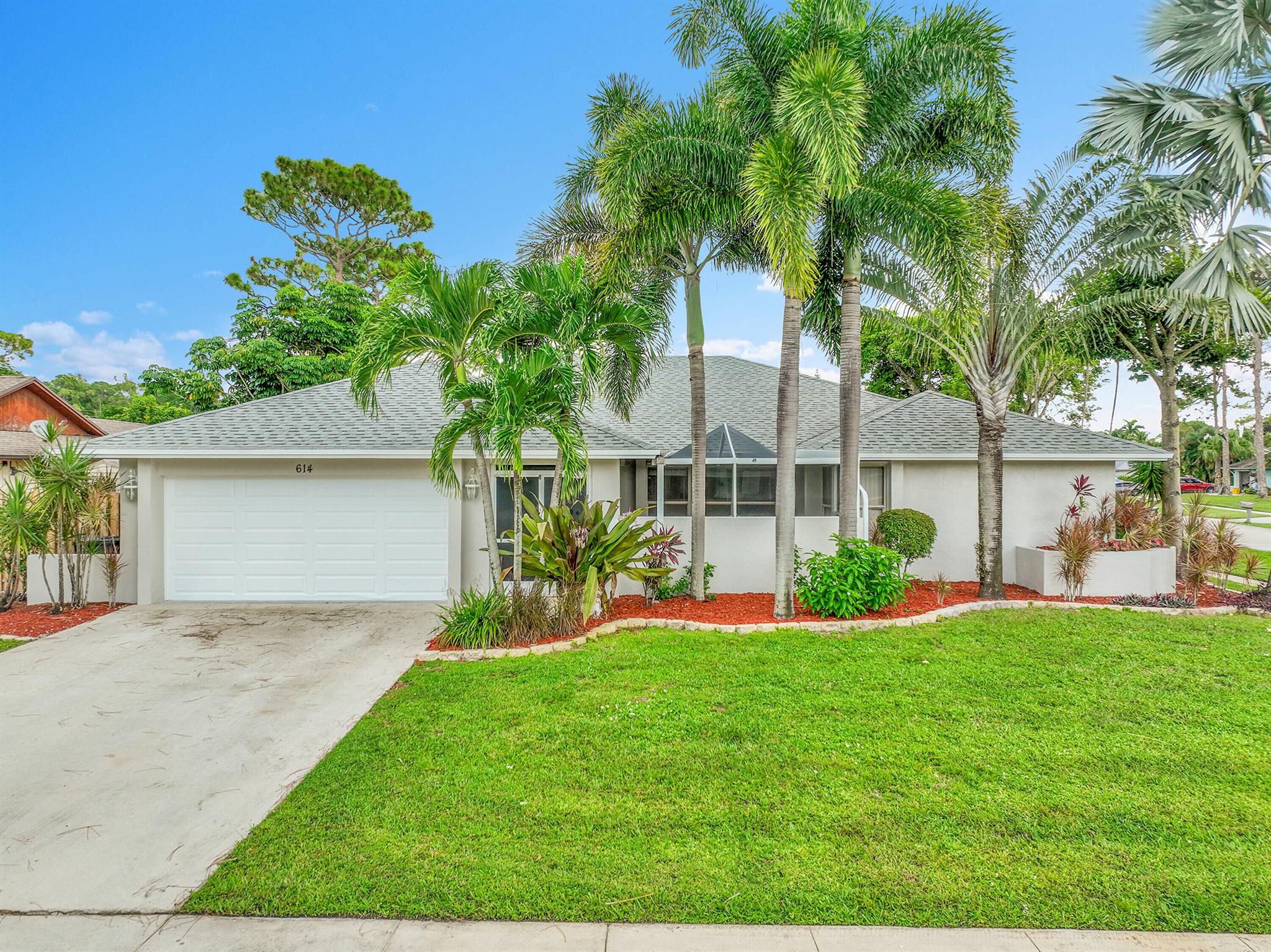 Beautifully renovated pool home in the non-HOA community of Sugar Pond. Situated on a large, lush corner lot, this single-story residence offers exceptional curb appeal and a prime location for year-round living. Golf carts are permitted in Wellington, and the home is zoned for A-rated schools. Ideal for extended stays for the savvy equestrian to enjoy multiple Winter Equestrian Festival seasons at a discounted price compared to seasonal rental. The home features a spacious front screened-in patio, perfect for an indoor garden or tranquil coffee spot protected from mosquitoes. Double door entry leads to a bright interior with tile flooring and volume ceilings, showcasing a direct view of the sparkling blue inground pool with a waterfall.
