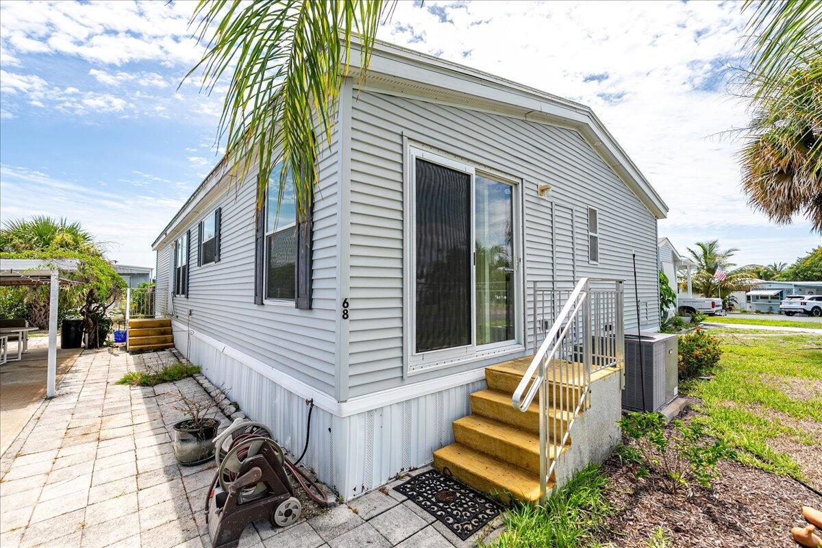 MOVE IN READY! Discover this 3Bed, 2Bath, w/carport and over 1320 SF! This is a manufactured home in Woodbridge, 55+ CO-OP community in Hobe Souns. The home features an open floor plan w/ large living room,fully-equipped Kitchen w/new Refrigerator, wine cooler, new stackable washer/dryer & Breakfast nook. Large Master Bedrom w/Spa Tub, dual sinks, & step in tile shower. Storage shed included! This 2005 PALM HARBOR features solid 2X4 construction able to withstand 130 mph winds - hurricane windows, Plywood subfloors. City Water & Sewer! The seller updated the Membrane roof in 2017 and A/C replaced in 2015! Excellent location close to shopping, gold and area beaches! A short drive to Tequesta, Jupiter and Stuart! Woodbridge is an active 55+ park w pool, shuffleboard & lots of activities!