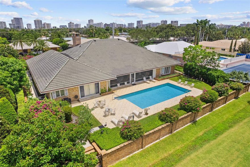 First time on market: George Storrs designed estate built as personal residence of builder/philanthropist Harry Mangurian. 6000+SF under AC, Chicago Brick over concrete. Walled/gated elevated fortress. 4BR 4Bth+Study/Den (5thBR), oversized 3Car Garage+ AC Attic storage. 600+ sf covered screened porch looks out at 40x20 heated pool across 7, 3, 13 & 14 fairways of "Crown Jewel of Ft. Lauderdale" Robert Trent Jones designed Coral Ridge Country Club championship golf course. Great Room w vaulted ceiling & fireplace. Main Bedroom has dual Baths w sep tub/showers & large walk in closets w built-ins. Pool & golf course views from Formal Dining Room,Kitchen,Breakfast Room,Family Room,Laundry Room & Main Bedroom. 10ft ceilings,wide hallways. Orchid House. 50KW whole house generator.