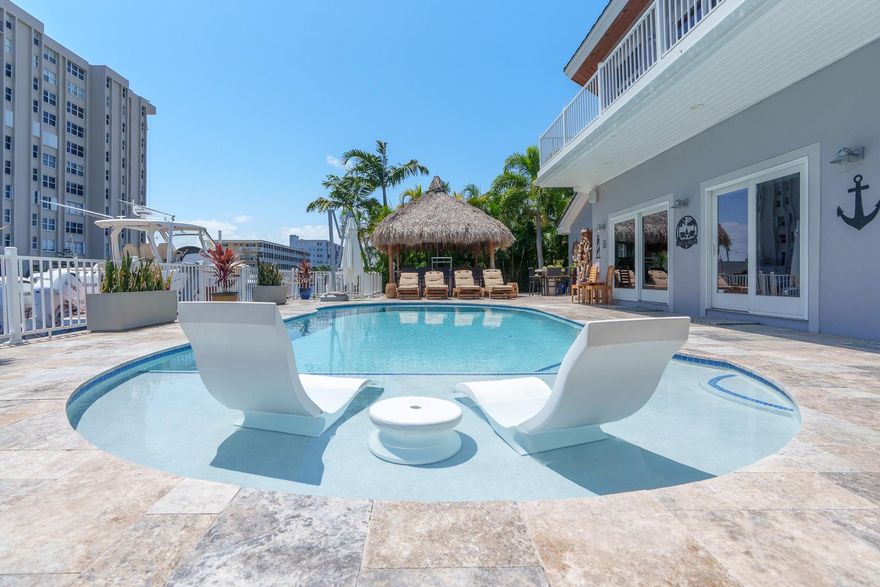 PRICE ADJUSTMENT - WATERFRONT LUXURY AT ITS FINEST! This captivating home in the prestigious Coral Ridge Country Club neighborhood boasts a dream layout. This fully remodeled home offers a seamless indoor-outdoor flow perfect for hosting gatherings. No fixed bridges provide easy access to the open waters, complemented by a 22,000-pound boat lift & a sprawling 100-foot dock. The allure continues with a saltwater pool, spa w/ pergola & a large Tiki Hut featuring full kitchen – without a doubt an entertainer's paradise. For added convenience, a natural gas whole home generator ensures continuous power. With two owner's suites, three more bedrooms, 4.5 baths, & an office/den, there's ample space for family or guests. Embrace the boater's lifestyle and live the essence of waterfront elegance.