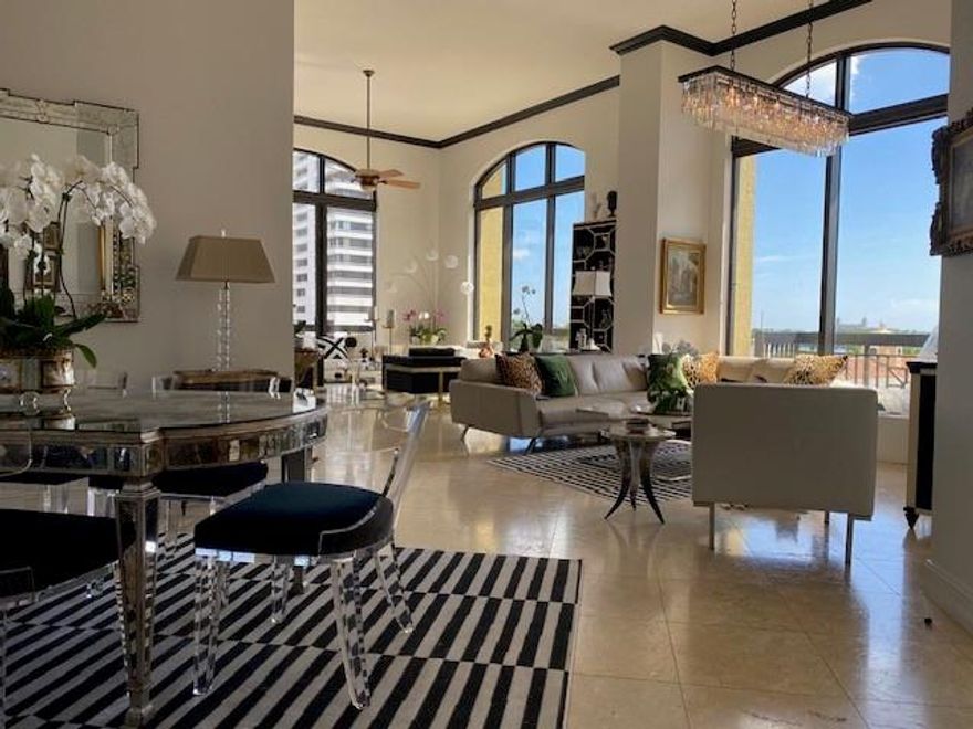 Dazzling 14 ft ceilings and dramatic floor to ceiling windows with motorized shades sets this light filled unit apart from others while boasting 5 balconies, 2 bedrooms, 2 1/2 baths, gorgeous light fixtures and views of the Intracoastal Waterway and the iconic Breakers Hotel. Custom built closets maximize storage along with a hallway storage room and 2 parking spaces just steps from the front door. Live within walking distance of Worth Avenue, Kravis Performing Arts Center, Norton Art Museum, waterfront activities, Green Market, weekly free concerts, boat show, restaurants and shopping. Enjoy the luxurious Florida lifestyle with an enormous resort style rooftop pool, sauna and steam rooms, grill area, party room, exercise room, newly remodeled hallways, concierge, valet, pet relief area. Chandeliers in master bath and owner's bedroom do not convey.