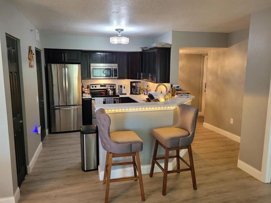 Updated!  and stunning , 3-bedroom unit with split floor plan and open kitchen/living style. The kitchen is updated with quartz counters and espresso modern cabinets. Bathrooms have updated cabinets and quartz counters. Hardwood gray floors. This Unite is Located on the 1st floor, and corner unit  (iluminated Rents : Basic cable, water, gated and common area  (exercise area, clubhouse, pool, spa, grills, sand volleyball, park), and gated entrance. New impact windows, the Building has just been painted and has a new look.
