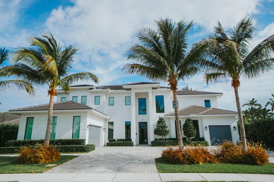 2022 Palm Beach waterfront residence, where timeless design meets modern luxury. Crafted to blend indoor and outdoor living, this home features soaring ceilings, expansive impact windows and doors, and stunning white oak hardwood flooring complemented by custom-built cabinetry throughout—creating a bright, open, and sophisticated atmosphere. The chef's kitchen is a true centerpiece, complete with dual islands, marble countertops, premium Wolf appliances, a Sub-Zero refrigerator, and a spacious walk-in butler's pantry. Designed for both comfort and convenience, the home offers upstairs and downstairs laundry rooms, a private guest suite with cabana bath, a dedicated home gym, and a sleek custom glass staircase. With 5 bedrooms and 5.1 bathrooms, the layout is both functional and flexible.  The upstairs primary suite is a private retreat featuring dual vanities, a spa-like bath, an expansive custom walk-in closet with center island, and a separate shoe and accessory closet. Additional highlights include en-suite bathrooms in all secondary bedrooms, premium TOTO fixtures throughout, and a pre-installed elevator shaft for future convenience. Outdoors, enjoy 90 feet of seawall with dock space, perfect for boating enthusiasts. The resort-style backyard is designed for entertaining, featuring a pool with spa and fire pits, a covered patio with electric screens, outdoor kitchen with gas grill, and a covered balcony for elevated views. Additional features include a 3-car garage with acrylic flooring, full-home security system with cameras, electric shades, surround sound, and designer textured wallpaper accents.