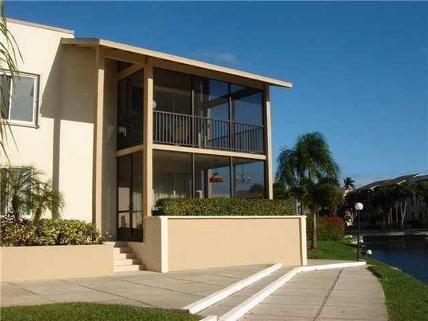 One of the best locations in the popular and desirable 55+ community of Longwood. Spacious and sunny first floor corner condo. Views of lagoon, pool and well maintained grounds, overlooking BallenIsles Golf Course. Screened wrap around patio. Pleasant master suite with sitting area and two closets, one walk in.  Both bedrooms large enough for king beds. Separate storage unit. Covered carport close to unit. Great pool and barbeque area. Clubhouse with saunas, community and exercise room, billiards and library. Tennis courts, shuffleboard. Conveniently located off PGA Boulevard near golf, marinas, fine dining and shopping. Short drive to beach and minutes to Palm Beach Airport.