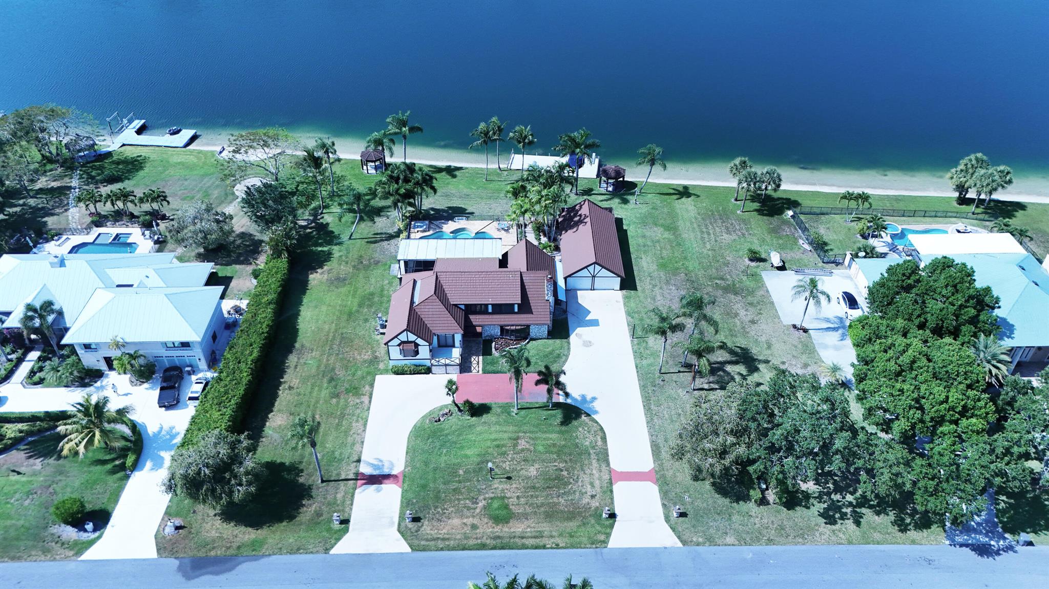 Prestigious Banyan Lakes Opportunity! Rare chance to own a prime lakefront acre in this gated Palm Beach County community with 260 ft of private shoreline on a water-ski and jet-ski friendly lake. Included with the property are fully permitted architectural plans for a 5,085 sq ft luxury estate (7,400+ total sq ft) featuring 5 beds, 4 full baths, a cabana bath, powder room, den, salt-chlorinated pool, 2 wood-burning fireplaces, and an oversized 4-car garage. Plans are customizable to your personal taste. Enjoy a 50-ft boat dock with electric lift, twin gazebos, and panoramic views. Minutes to Wellington. One of only three private ski lakes in the region--this is a rare, ready-to-build waterfront gem