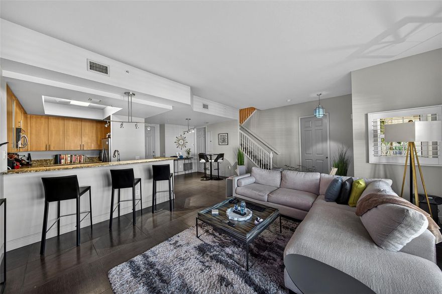 Spacious, bright and open floor plan with over 1,700 sf interior space. High ceilings, modern lighting and fixtures, upgraded flooring, plantation shutters, covered front terrace, two generous sized bedrooms with balconies, custom walk-in closet, and an upper level loft/den/tv room/office. Located on the quiet side of the complex with one under building parking space and storage. Complex is gated, pet friendly, with EV charging stations, on-site management and more. Amazing pool area, community room, fitness center, media room and canal side dock. Centrally located close to beach, shopping, restaurants, downtown and vibrant Wilton Drive. Well financed with no fee increase for 2026, new roofs and fully funding reserves. Fees include internet/cable, water, trash, insurance and all amenities.