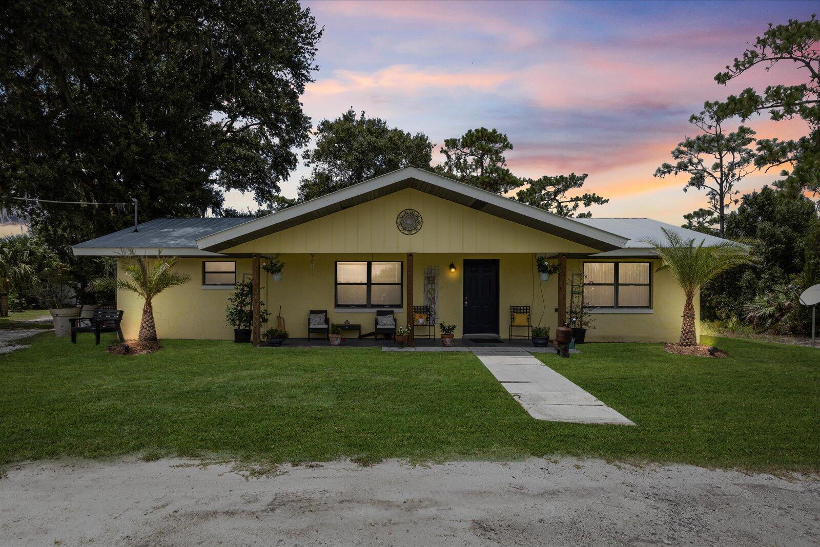 Step inside this charming 3/2 CBS home on a newly fenced 1 acre lot, plentiful with all kinds of fruit trees & you will fall in love! The fence has a large swinging door for large vehicles, trailers, boats, etc & further down there is another set of double doors to bring in vehicles or equipment etc. There is even a chicken coop, so you can enjoy fresh eggs! The property is also zoned commercial so the possibilities are endless! The kitchen & bathrooms have recently been updated too! The kitchen has new stainless steel appliances & a beautiful tile backsplash. The bathrooms have both been updated with new tile wall surrounds & a new vanity in the guest bathroom! The washer & dryer are newer as well! You will also find upgraded luxury vinyl plank flooring throughout! Sit outside on your