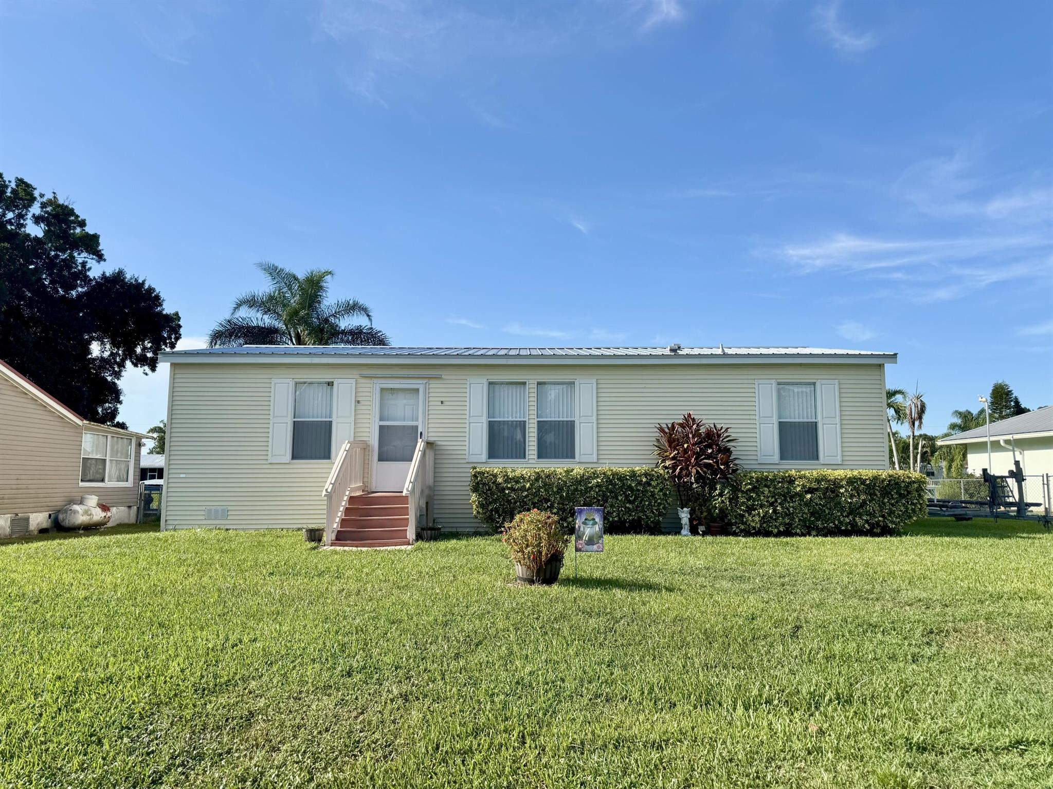 LAKE ''O'' Access! The TREAT of Treasure Island! Pristine, 2017 Palm Harbor Manufactured home. 3 Bd/ 2 Ba, open concept. Split plan and spacious MB. Bkfast bar, pantry and nice utility room. Crown Molding. Beautiful water views with no one living behind you. Seawall and party dock. DWMH is Windzone 3. Metal roof, New HWH, Hurricane Shutters incl. Sewer fee paid. Storage shed. Sellers have caught an 8lb Bass off the dock! Only minutes to the creek and famous Lake Okeechobee! MAKE all your FISHING DREAMS Come True! Dimensions are approximate, must measure for exact.