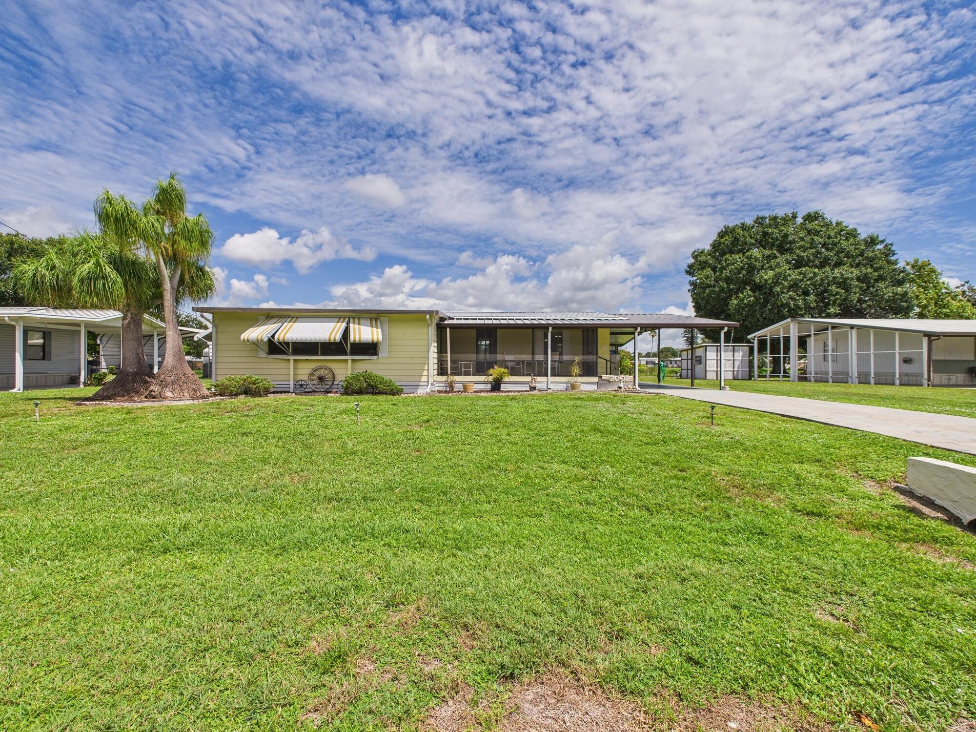 This spacious 2BD/2BA double-wide offers a mother-in-law suite/second master in the front addition and sits on a 15-acre pond with the same water as Lake Okeechobee--perfect for fishing, paddle boating, and relaxing by the picturesque wooden seawall. Inside, enjoy an open layout with a second living area off the guest room. Outside features include a screened front porch, huge screened back porch, full carport, two sheds/workshops, city water/sewer, and no HOA. Peaceful waterfront living just minutes from town!