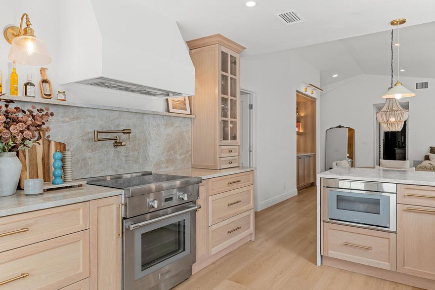 Gorgeous, fully renovated home located around the corner from Wellington International! This Bedford Mews residence offers a luxury, tasteful interior with 2 bedrooms, 2 baths, heated pool, 1-car garage, and 1,233 sf of living space. The captivating, modern backyard features marble tile throughout, covered patio with a passthrough-window bar top, an open patio ideal for dining and hosting gatherings,  cascading steps from the heated, platform plunge pool that will sure be the favorite seat in the house.  The fully customized interior showcases white oak vinyl floors, a beautiful kitchen with white oak cabinets, Taj Mahal Polished Quartzite counters, Thermador appliances, and a living room with a built-in bar! Both bedrooms feature unique designs and modern en suite bathrooms, with stunning details like natural stone sinks and walk in showers. Located on a quiet street surrounded by mature trees and greenery. Enjoy a quaint, low maintenance home that's move in ready!