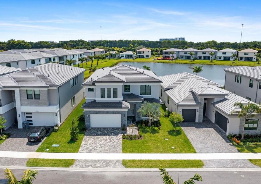 Welcome to Lotus Palm, where luxury meets contemporary living in the sought-after Mariana model with 5 bedrooms and 5 full baths. This exceptional 2-story home is a chef's dream, featuring a stunning island kitchen with quartz countertops, double ovens, and sub-zero refrigeration, all opening up to a spacious family room with gorgeous views of the lake. The home boasts oversized bedrooms with walk-in closets, complemented by hardwood floors, volume ceilings, and impact windows and doors throughout, offering a perfect blend of elegance and practicality. Outside, residents can indulge in a resort-style lifestyle with access to tennis and pickleball courts, a sprawling pool and spa, a gourmet restaurant, a kids' room, a splash park, and a playground, providing endless entertainment options for all ages. Located in the heart of Boca Raton, this home offers a great location with convenient access to the turnpike, mall, shops, schools, and entertainment, making it the perfect place to call home for those seeking both luxury and convenience.