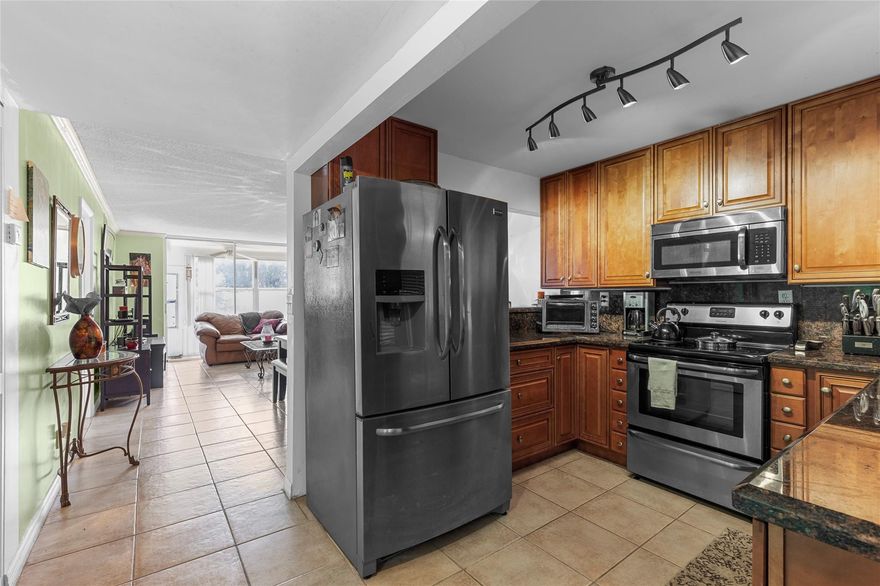 Beautiful water view updated 1 bedroom, 1 1/2 bath condo situated on the corner of the first floor, very bright with extra windows and comes tastefully furnished ready for move-in.  The Kitchen has elegant granite counters and stainless steel appliances. The kitchen leads to a spacious dining/living room area with a bonus Florida room. Tile flooring throughout the unit, all appliances, water heater and AC units have a transferable warranty in Phase III, you'll have access to great amenities such as a golf course, tennis courts, pickleball court, Shuffleboard, cable, water, gym, billiards, bingo theater, Jacuzzi heated covered pool, sauna, ping pong, comedy shows and more. Its like living in a resort in a resort every day