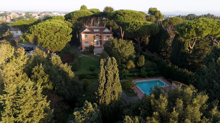 VILLA GUCCI, ROME, ITALY! In the late 1940s, Aldo Gucci, who moved to Rome from Florence to follow the expansion of the family business, began construction of the villa, which was completed in 1951. The villa features an inspiration to a mix of English style with Tuscan accents. In fact, Aldo's wife was born in the United Kingdom, which is why there are characteristic bow-windows and other typical decorative elements on the two facades of the house. Aldo moved there with his children and their respective spouses; then, as the family grew, the children moved to other homes, but they always gathered for holidays or other important events in the ''Family House''.The location is a stone's throw from the historic center, in a prestigious residential area surrounded by prestigious villas and embassies, quiet and private, opposite a renowned international school. The property is surrounded by a 10,000-square-meter park, and behind a private gate is a majestic main entrance surrounded by trees, at the end of which stands the first main villa. Below the vast garden, with a separate entrance, is a second villa in need of renovation.
The English-elegant villas are refined and bright, with large windows overlooking the green parkland. An indoor garage and outdoor space are available for car parking. The main villa has on the ground floor a large kitchen, a dining room, a hobby room with billiards and fireplace, a study and seven bedrooms, each with en-suite bathrooms. On the upper level is a bedroom with bathroom and access to the rooftop with a beautiful terrace; the priceless asset is the view of the Altar of the Fatherland rising in the center of Rome, visible in the distance.
In the greenery surrounding the villa, there is a magnificent swimming pool, served by an outbuilding used as a dressing room with bathrooms, a large garage and a tool shed. Beyond the garden is the second villa, ideal for those who want home and office in the same residential context, or it can be used as a guest house or as an investment for those who want to make an income from it.