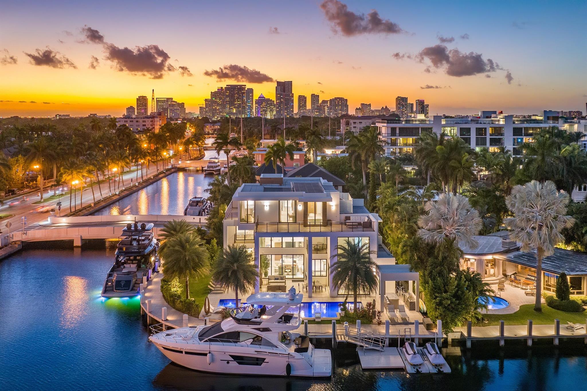 Indulge in the extraordinary at 2 Fiesta Way, where contemporary-inspired opulence redefines the standards of luxury living. This three-story point lot estate seamlessly blends sophistication, design, architecture, and elegance. With a total square footage of 7,661 and an interior space of 5,926 square feet, the estate has 6 bedrooms, 7 full bathrooms, and 1 half bathroom. The residence's allure extends to a remarkable 220-foot concrete dock, catering to the most discerning yachting enthusiasts. Upon entering this refined estate, an open-layout design allows the space to fill with natural light through floor-to-ceiling windows. Positioned to the right of the entrance, a sleek glass elevator stands ready to transport guests to all three floors of this magnificent property.