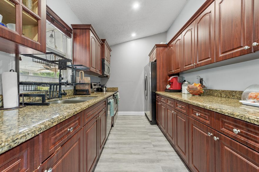 Welcome to your private retreat, 13254 79th Court N, in The Acreage! **SELLER HAS 3.5% assumable FHA mortgage**. Nestled at the end of a quiet street, this beautiful home sits on 1.31 acres in a wonderful neighborhood that offers both privacy and convenience. Step inside and you'll be greeted by a bright and open living and dining area, perfect for gatherings and entertaining. Soaring vaulted ceilings create an airy, inviting atmosphere, while oversized windows fill the space with natural light and provide serene views of the expansive backyard. The newly remodeled kitchen is a chef's delight, featuring abundant cabinetry, gorgeous granite countertops, and stainless steel appliances. This home offers 4 spacious bedrooms and 2 bathrooms, designed with comfort and versatility in mind. The large master suite is filled with natural sunlight and includes a beautifully updated bathroom with granite vanity. Three additional bedrooms provide more spaces for guests, a home office, or even a fitness room. Additional peace of mind comes with a 9-year-old roof and an 8-year-old septic system, giving you confidence in the home's long-term value. Step outside to enjoy a large covered patio, ideal for outdoor dining and entertaining. With over an acre of land, there's plenty of room to play, relax, and grow. The property also features fruit trees including mango, avocado, lemon, and ackee - a rare and delightful bonus! All this, while being just minutes from shopping, dining, and the airport for ultimate convenience. This home truly combines comfort, privacy, and value - a perfect fit for families and anyone looking to enjoy the best of Acreage living!